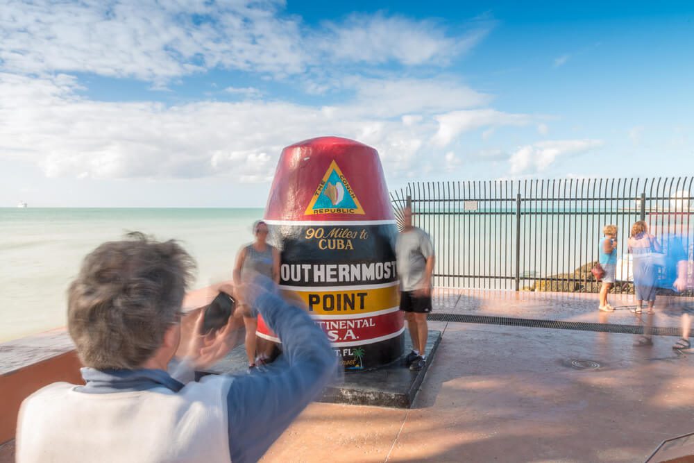 People taking a photo at the Southernmost Point Buoy, one of the free things to do in Key West.